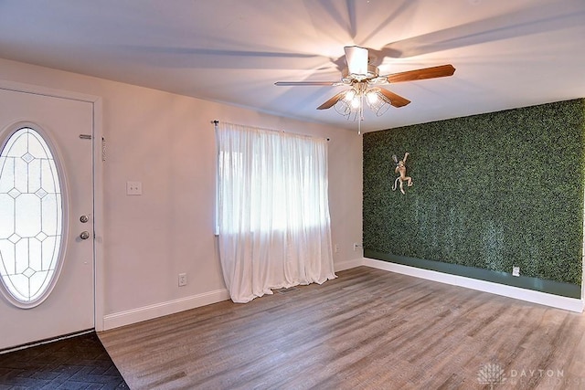 entrance foyer featuring visible vents, an accent wall, a ceiling fan, wood finished floors, and baseboards