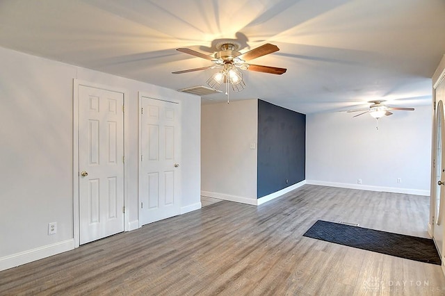 spare room with ceiling fan, baseboards, and wood finished floors