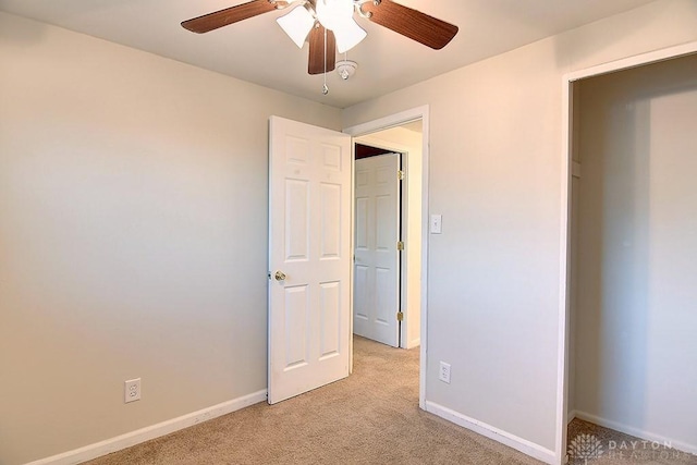 unfurnished bedroom featuring light carpet, ceiling fan, and baseboards