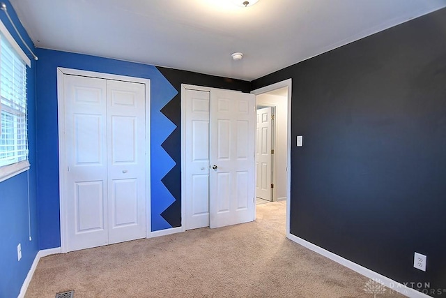 unfurnished bedroom with carpet floors, baseboards, and a closet