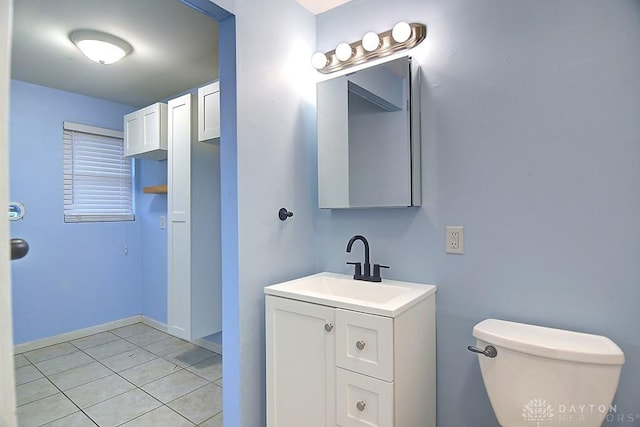 half bath featuring toilet, tile patterned floors, and vanity