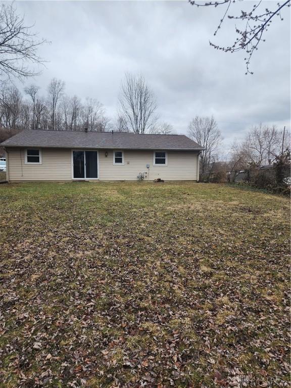 rear view of house featuring a lawn