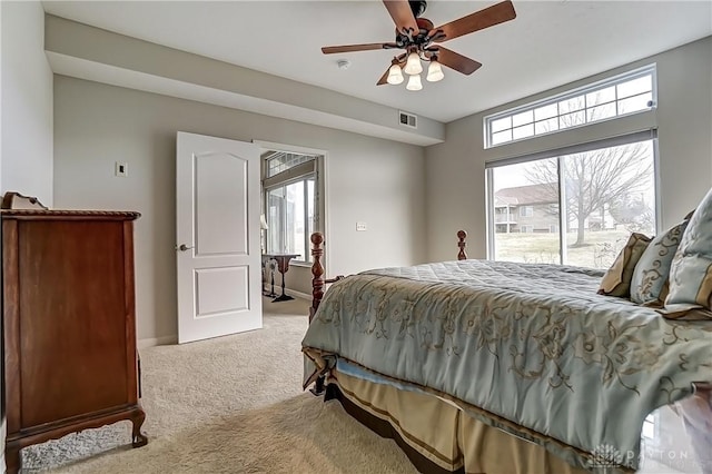 bedroom with access to exterior, visible vents, a ceiling fan, light carpet, and baseboards