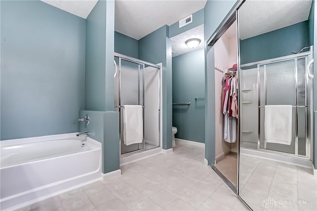 bathroom with a garden tub, a shower stall, visible vents, and a textured ceiling