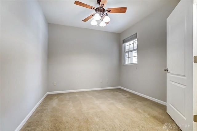 empty room with baseboards, a ceiling fan, and light colored carpet