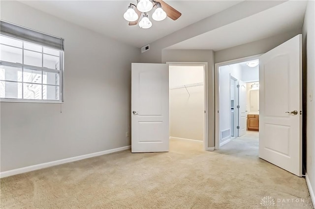 unfurnished bedroom featuring a closet, visible vents, light carpet, and baseboards