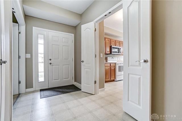 foyer entrance with light floors and baseboards