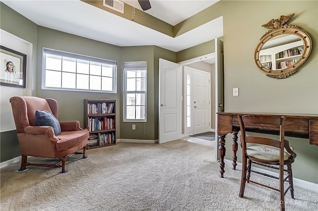 interior space with carpet floors, a ceiling fan, visible vents, and baseboards