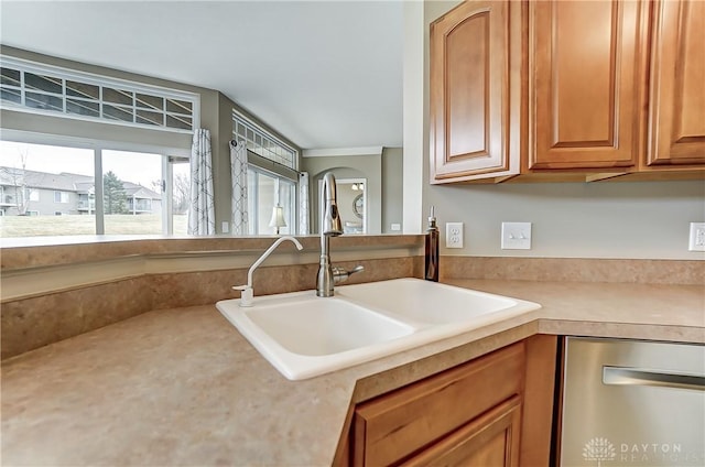 kitchen with arched walkways, light countertops, stainless steel dishwasher, and a sink