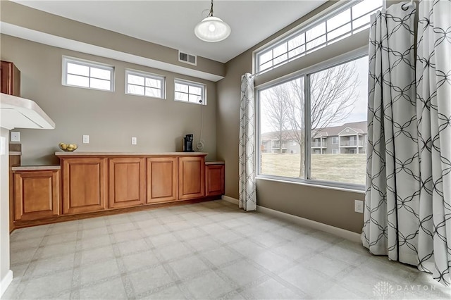 empty room with light floors, plenty of natural light, and visible vents