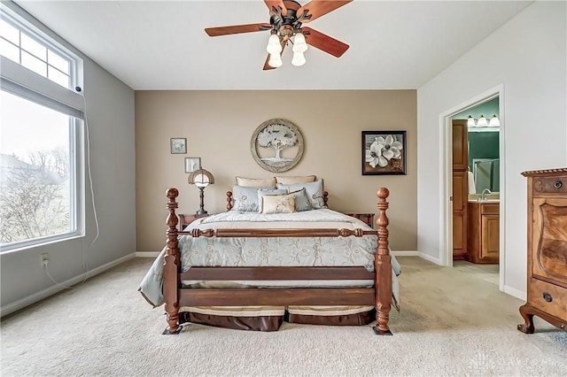 bedroom featuring multiple windows, baseboards, connected bathroom, and light colored carpet