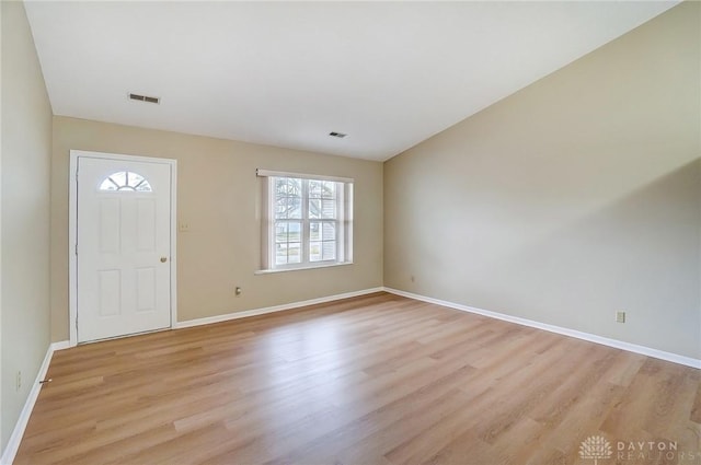 foyer entrance with visible vents, baseboards, and light wood finished floors