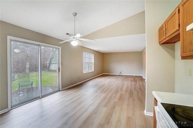 unfurnished dining area with light wood-type flooring, lofted ceiling, baseboards, and a ceiling fan