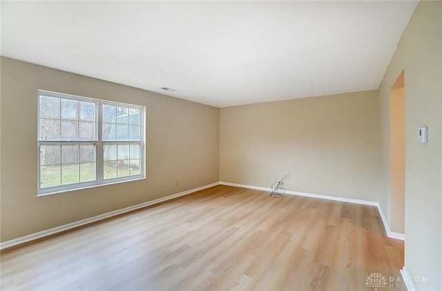 spare room featuring visible vents, baseboards, and light wood-style flooring