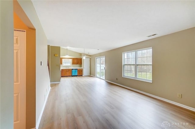 unfurnished living room featuring baseboards, visible vents, and light wood finished floors