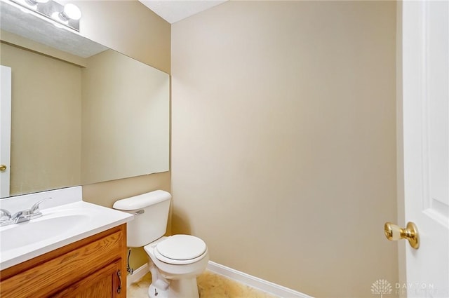 half bath featuring tile patterned floors, toilet, vanity, and baseboards