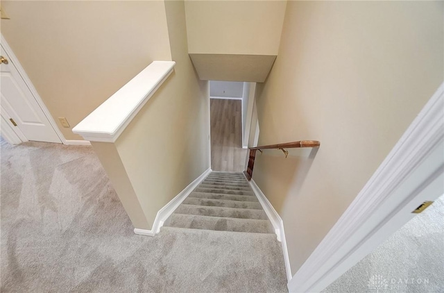 staircase with baseboards, a skylight, and carpet