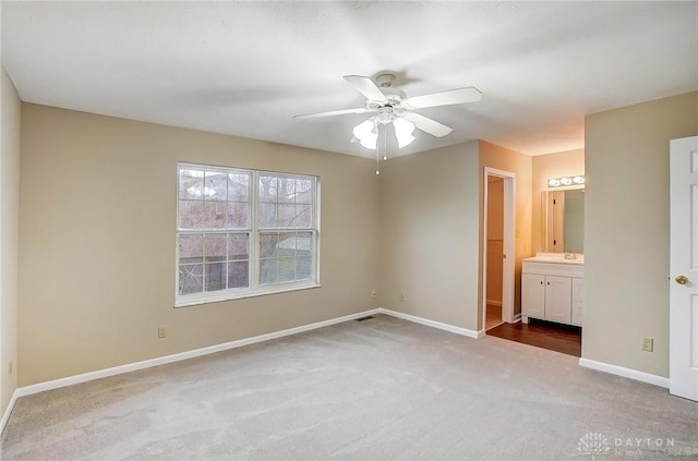 unfurnished bedroom with ceiling fan, baseboards, ensuite bathroom, and carpet flooring