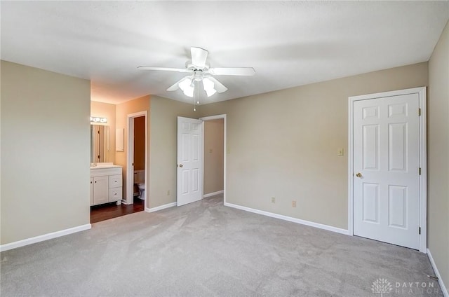 unfurnished bedroom with ceiling fan, baseboards, carpet floors, and connected bathroom