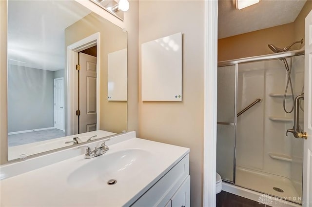 full bathroom featuring a shower stall, toilet, and vanity