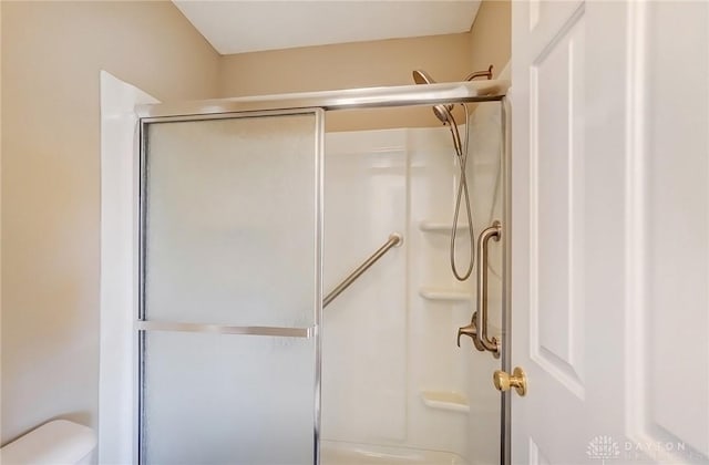 bathroom featuring a shower stall and toilet