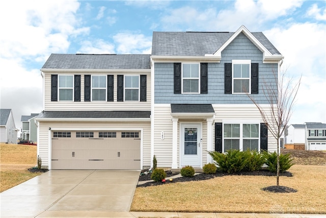 traditional-style home featuring a garage, concrete driveway, and a front yard