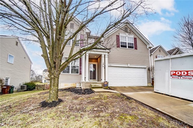 traditional-style home featuring concrete driveway, fence, an attached garage, and central AC unit