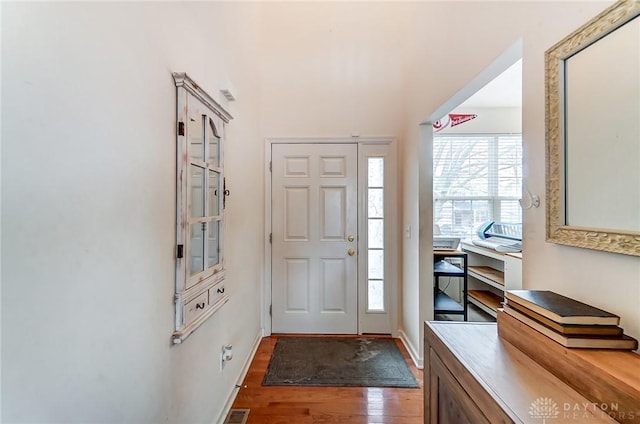 entryway with baseboards and wood finished floors