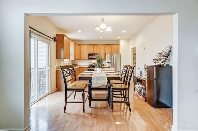 dining area featuring recessed lighting, a notable chandelier, and light wood finished floors