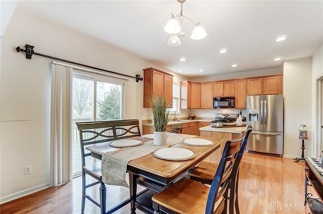 dining room with a chandelier, recessed lighting, and light wood-style flooring