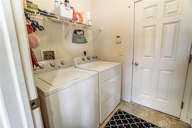 clothes washing area with washer and dryer, laundry area, and light tile patterned flooring