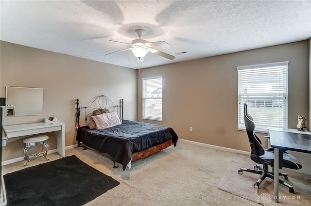 bedroom with light colored carpet, visible vents, a textured ceiling, and baseboards