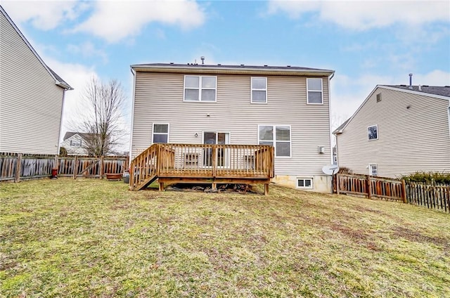 back of property with a fenced backyard, a deck, and a yard