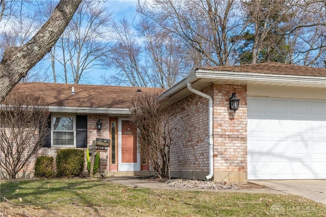 view of front of property with brick siding, an attached garage, and a front yard