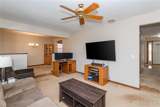 living room with ceiling fan with notable chandelier, baseboards, visible vents, and light colored carpet