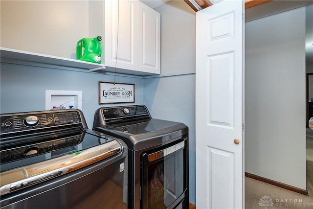 laundry area with washing machine and dryer, cabinet space, and baseboards