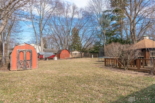 view of yard with a trampoline, an outdoor structure, a gazebo, and a shed