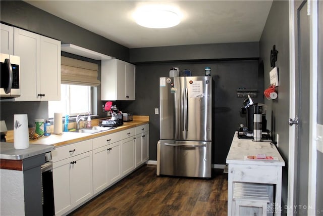 kitchen with dark wood finished floors, light countertops, a sink, and freestanding refrigerator