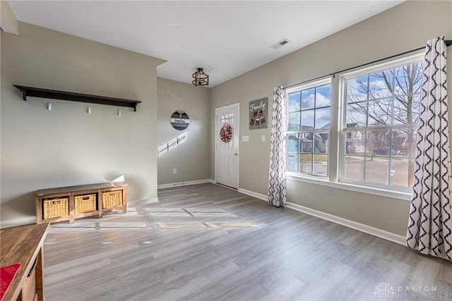 entrance foyer featuring visible vents, baseboards, and wood finished floors