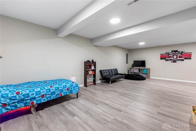 bedroom featuring visible vents, beamed ceiling, baseboards, and wood finished floors