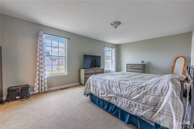 bedroom featuring a textured ceiling, carpet, visible vents, and baseboards