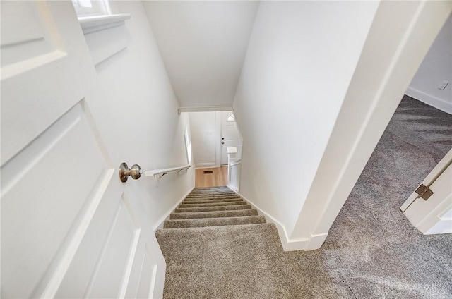 staircase featuring carpet floors and baseboards