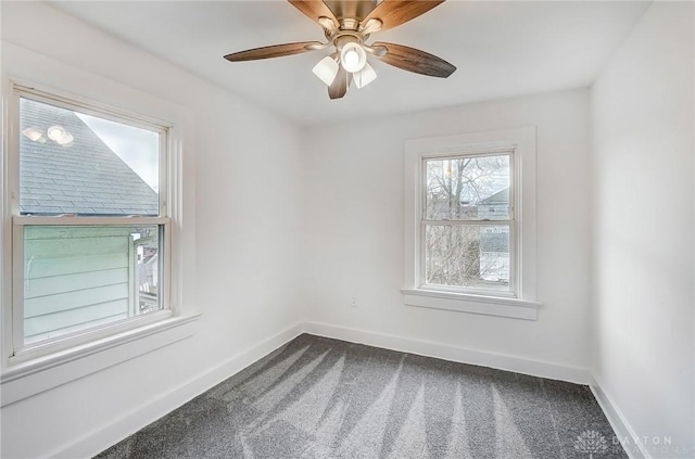 spare room featuring ceiling fan, dark carpet, and baseboards