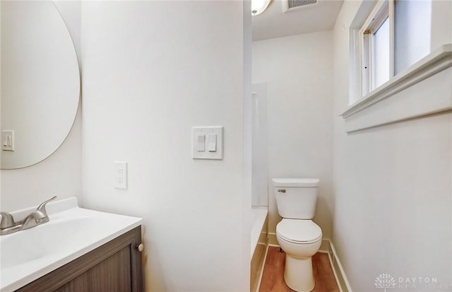 full bath featuring visible vents, baseboards, toilet, wood finished floors, and vanity