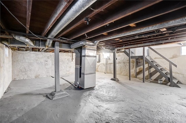 basement featuring heating unit and stairway