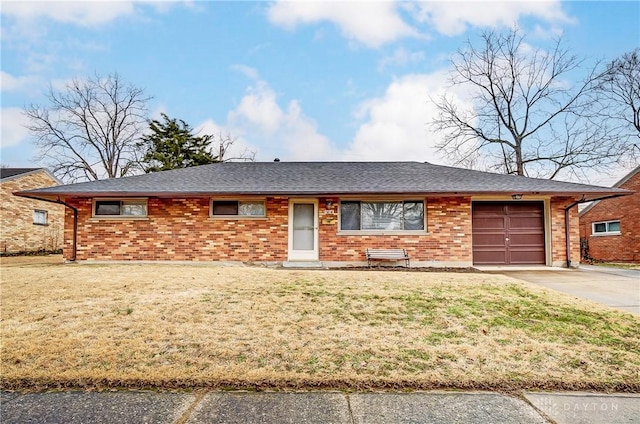 single story home with a shingled roof, a front yard, brick siding, and driveway