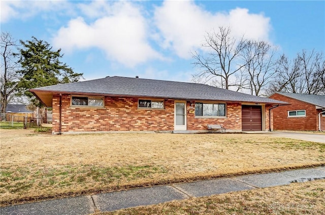 ranch-style home featuring brick siding, concrete driveway, a front yard, fence, and a garage