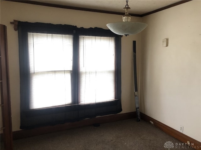 spare room with ornamental molding, a healthy amount of sunlight, and baseboards