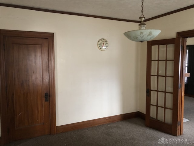 carpeted spare room featuring ornamental molding and baseboards