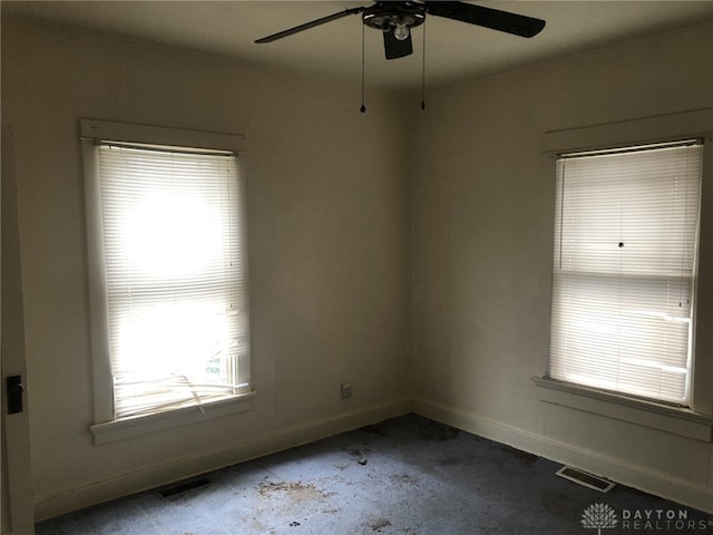 empty room featuring visible vents, plenty of natural light, and baseboards